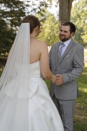 A tender moment between newlyweds as they share their first look in an outdoor garden setting.