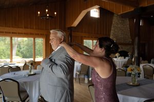Wedding party members sharing an emotional first look moment in a rustic wooden venue.