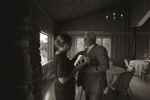 Dramatic black and white photo of wedding party members in a rustic indoor setting.