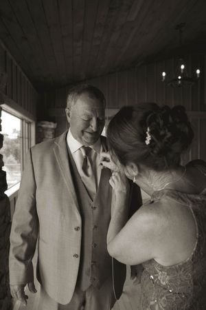 Intimate black and white wedding moment captured in a rustic indoor venue.