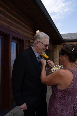 Emotional moment between wedding attendees on outdoor patio.