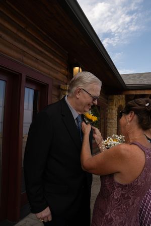 Wedding guests sharing a tender moment outside venue building.