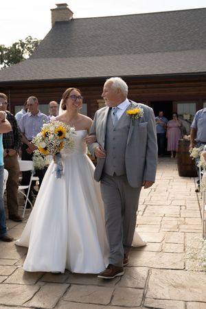 Wedding party lined up on stone patio during outdoor ceremony.