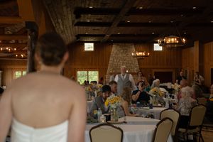 Wedding reception venue with elegant table settings and warm lighting in a spacious banquet hall.
