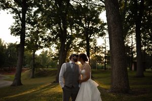 Silhouetted trees frame wedding couple during sunset portrait session.