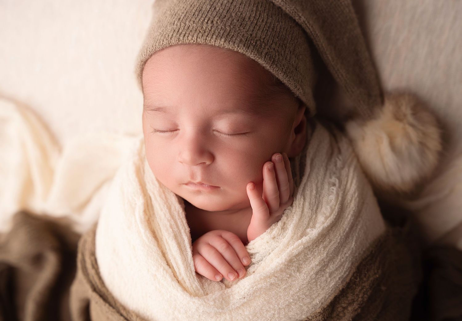 Miami Maternity photographer Sleeping baby wearing knit hat and cream wrap in soft neutral tones.