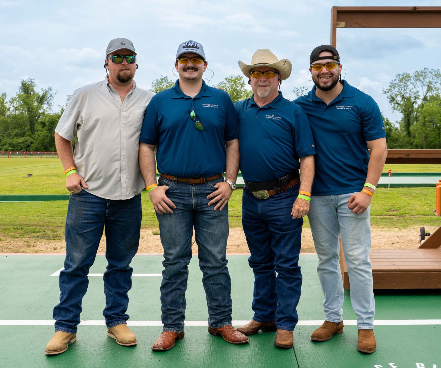 Group wearing matching navy blue uniforms and work boots stand together at an outdoor location.