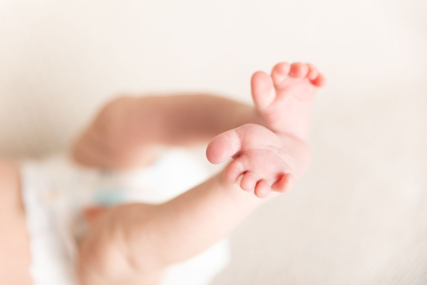 A close-up view of tiny baby feet against a soft white background.