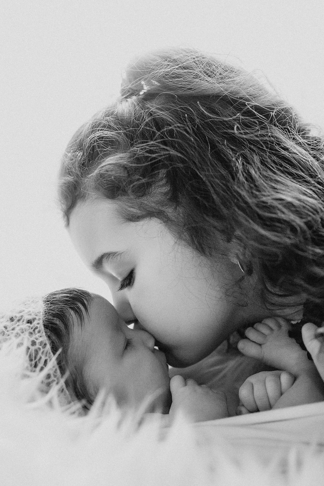 Dreamy side profile of sleeping child with curly hair against light background.