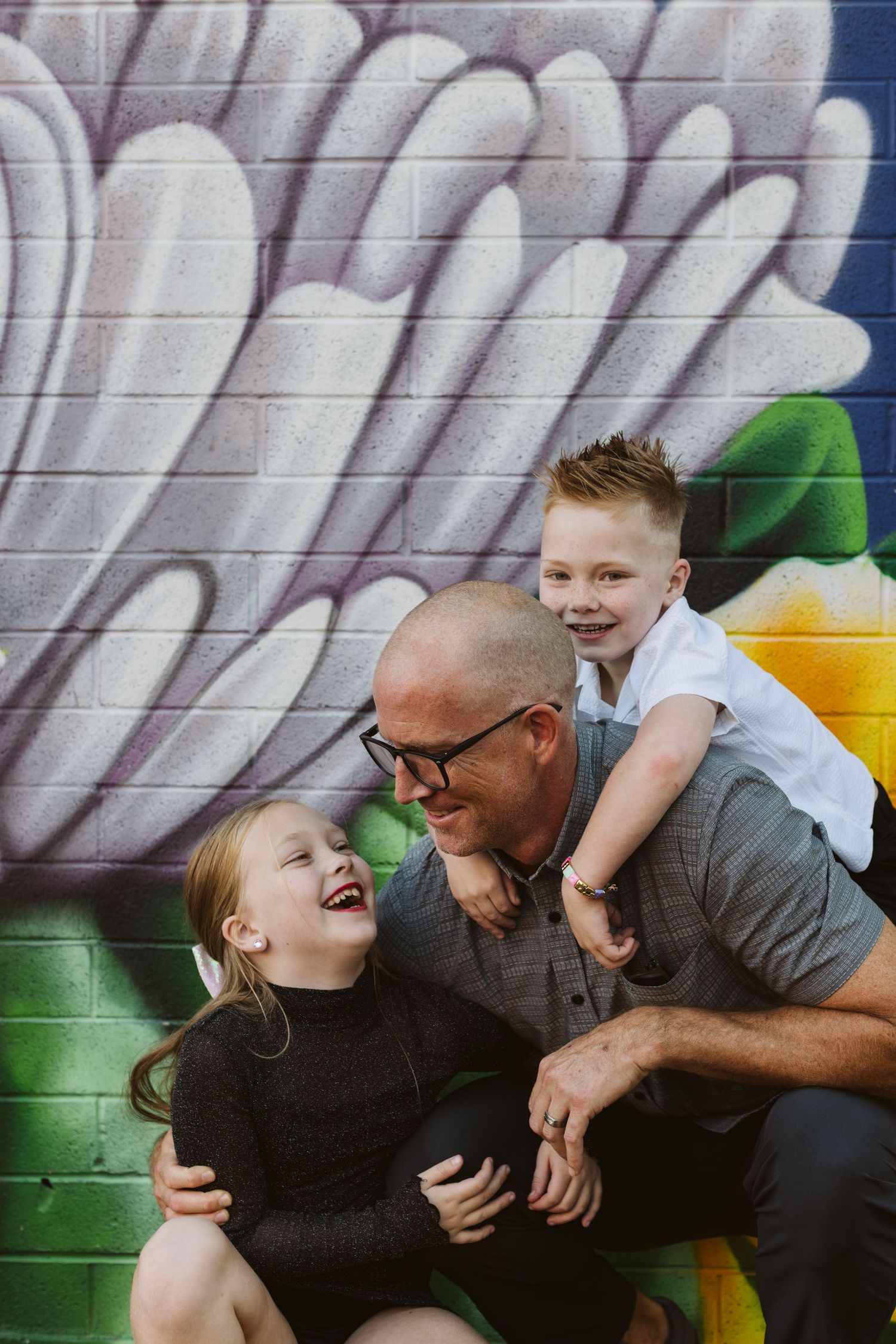 Candid moments of laughter and joy shared against a colorful graffiti wall background.