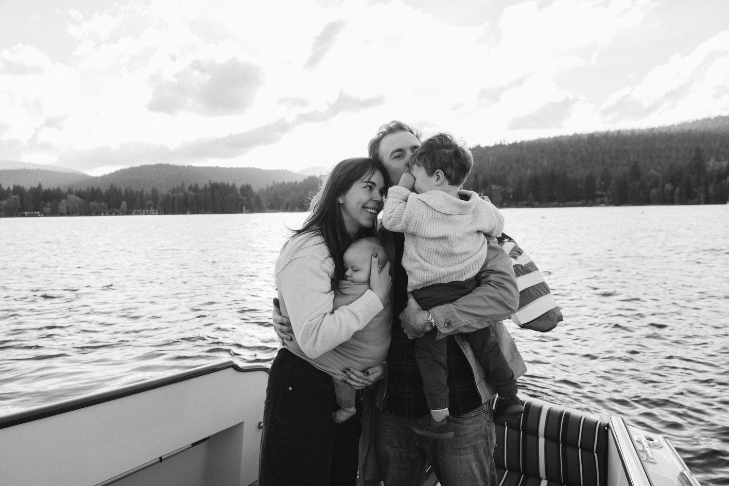 Tender family moment captured on a boat ride across a serene mountain lake.