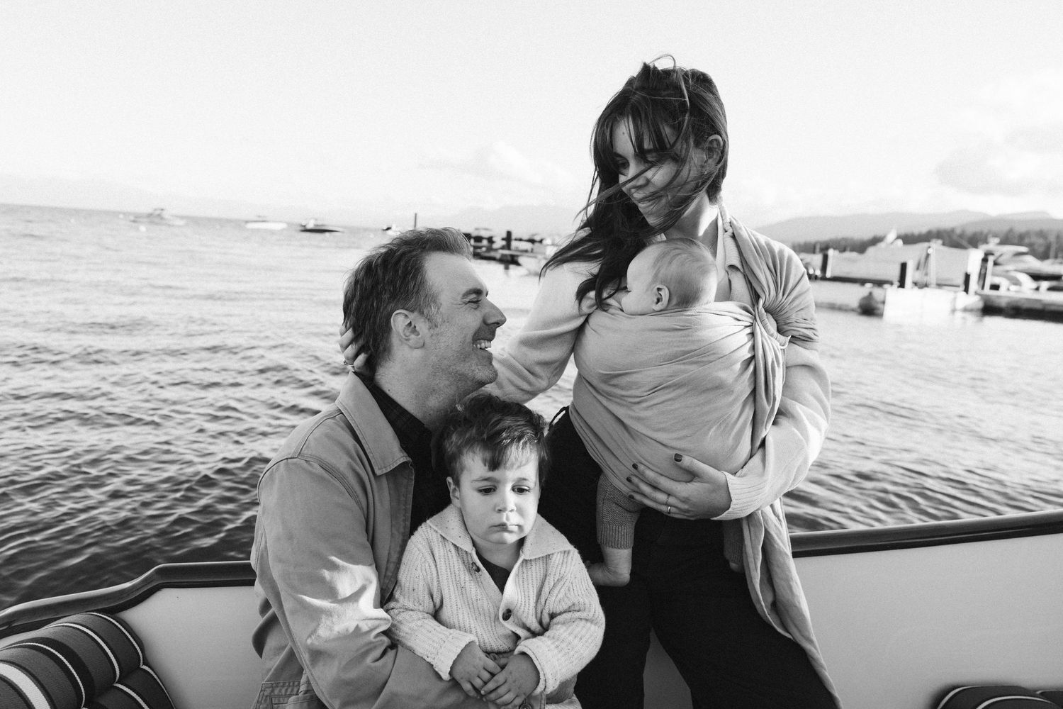 Candid family moments captured on a boat during a sunny afternoon.