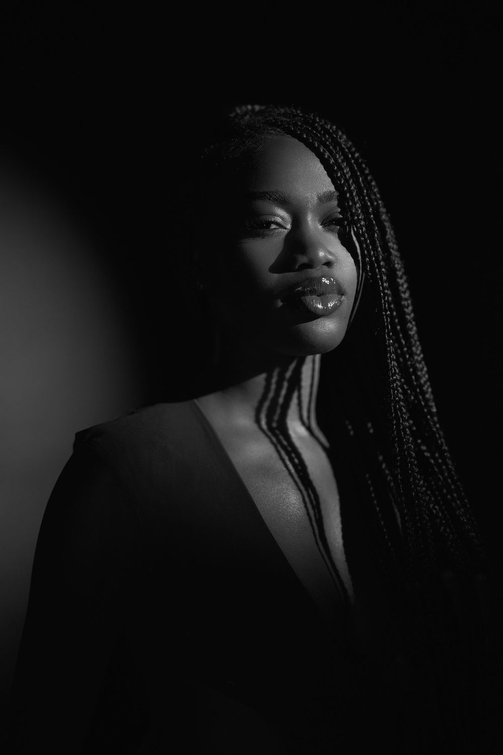 Dynamic black and white portrait series showing different angles of a person with braided hair in dark lighting.
