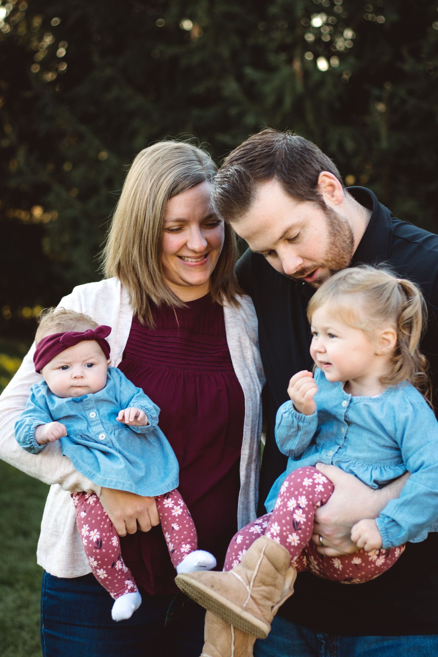 Parents holding their children close while laughing together during a candid family moment, metro Detroit family photography.