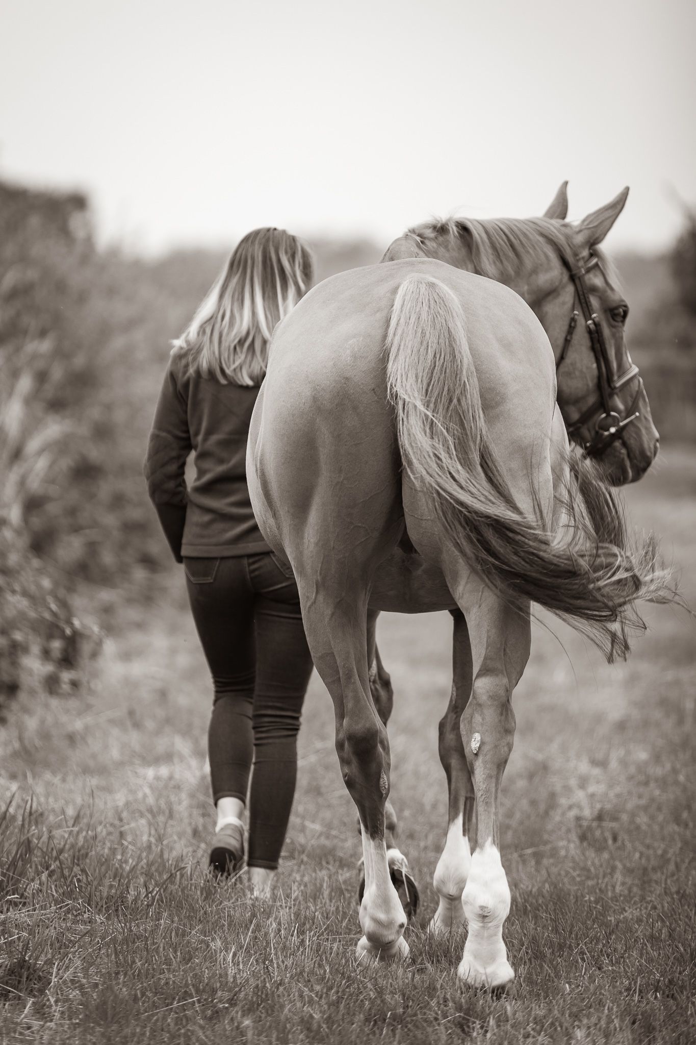 Young equestrian poses with palomino pony in a series of natural outdoor portraits showing their special bond.