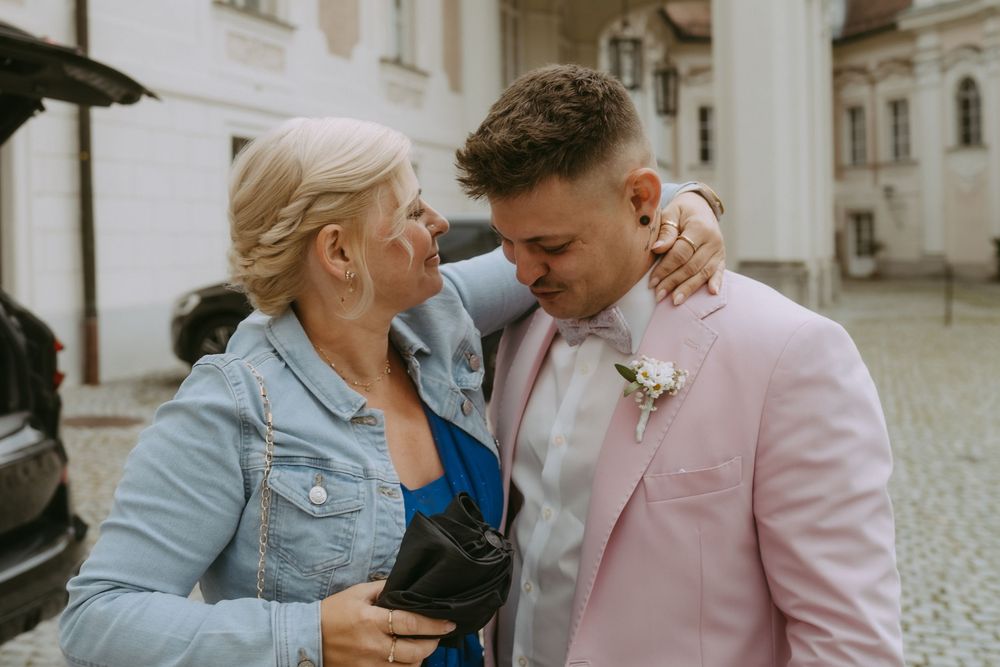 Couple sharing intimate moments in front of historic architecture.