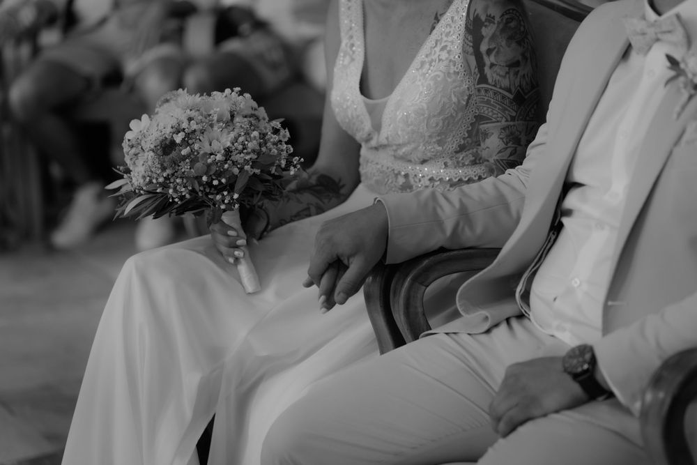 Black and white photo of wedding ceremony guests in formal attire.