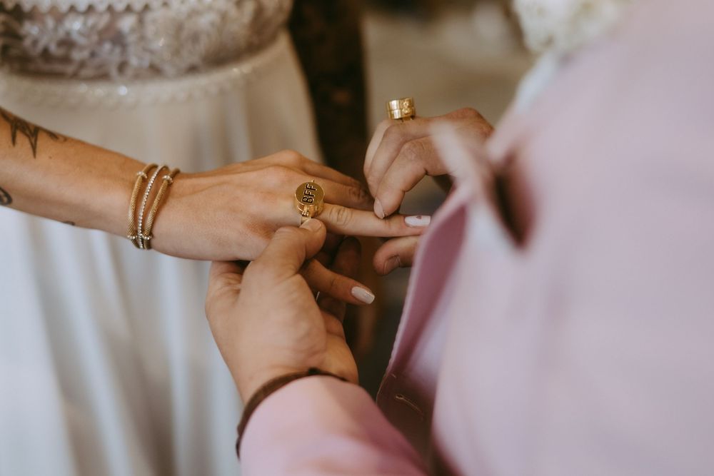 Close-up of hands exchanging rings during wedding ceremony.