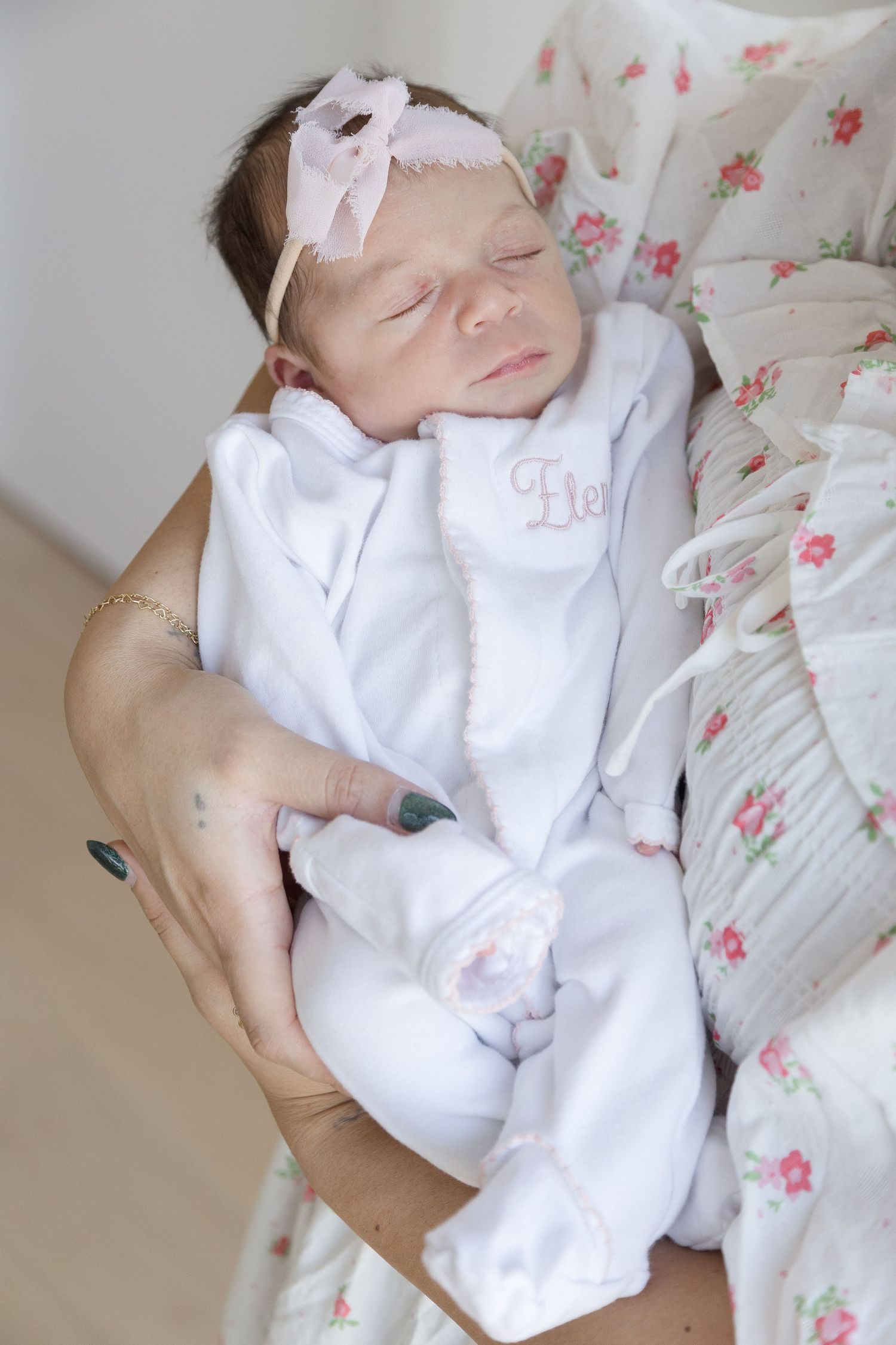 "Close-up of newborn sleeping peacefully in mother's arms in Washington DC newborn session."