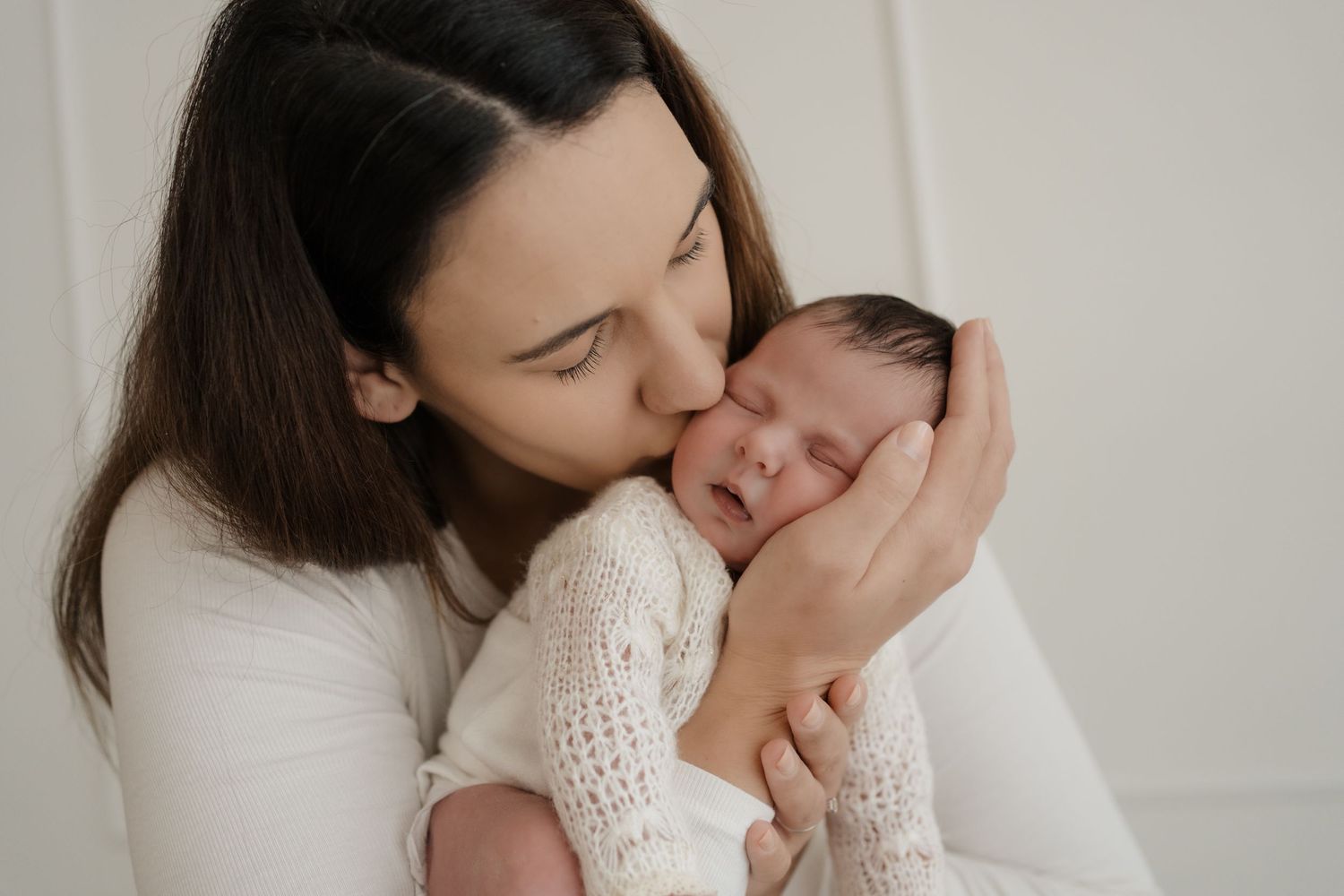 Parent and baby share intimate bonding moments in a series of tender black and white photographs.