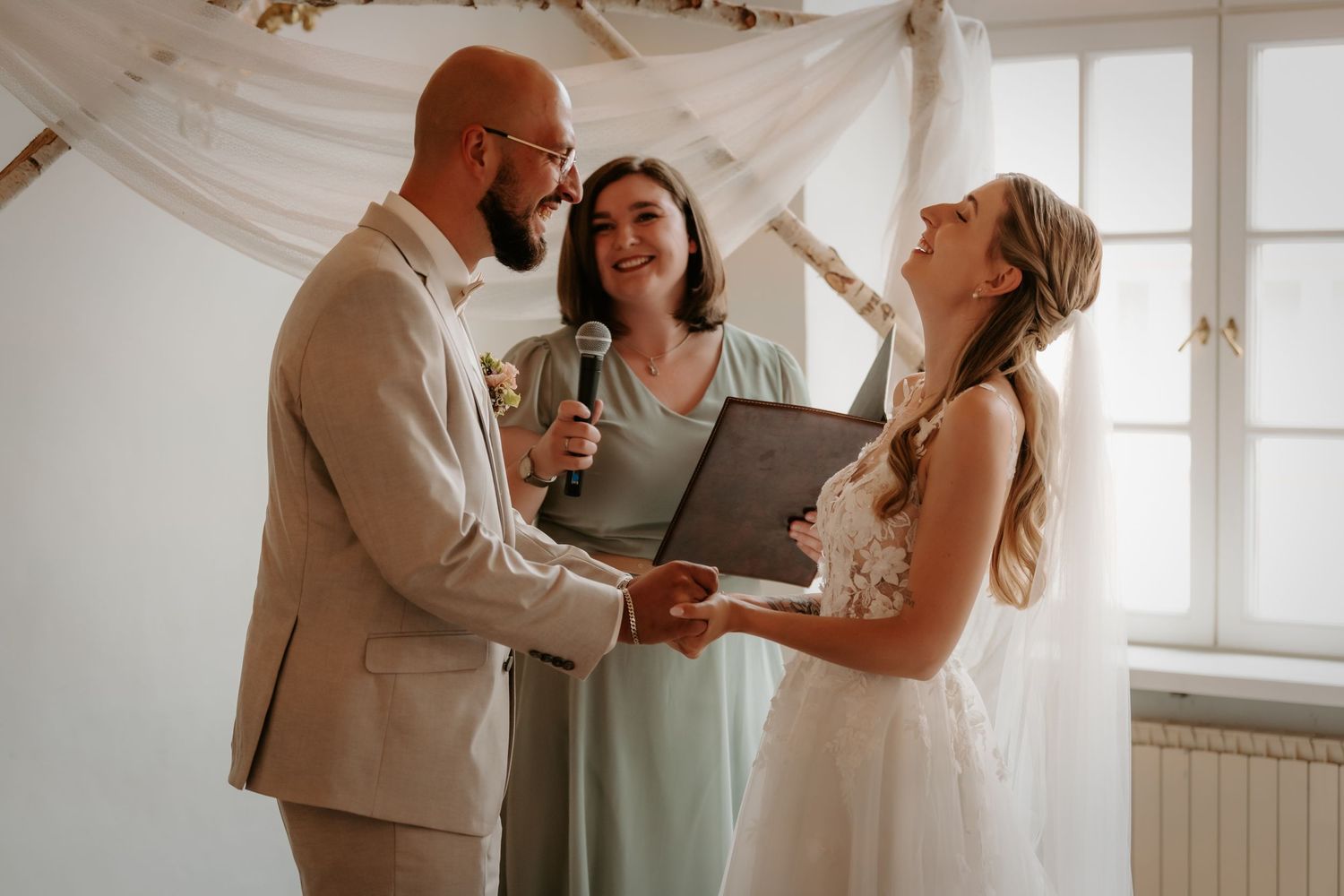 A joyful couple shares intimate moments while dancing together in a bright sunlit room with white walls.