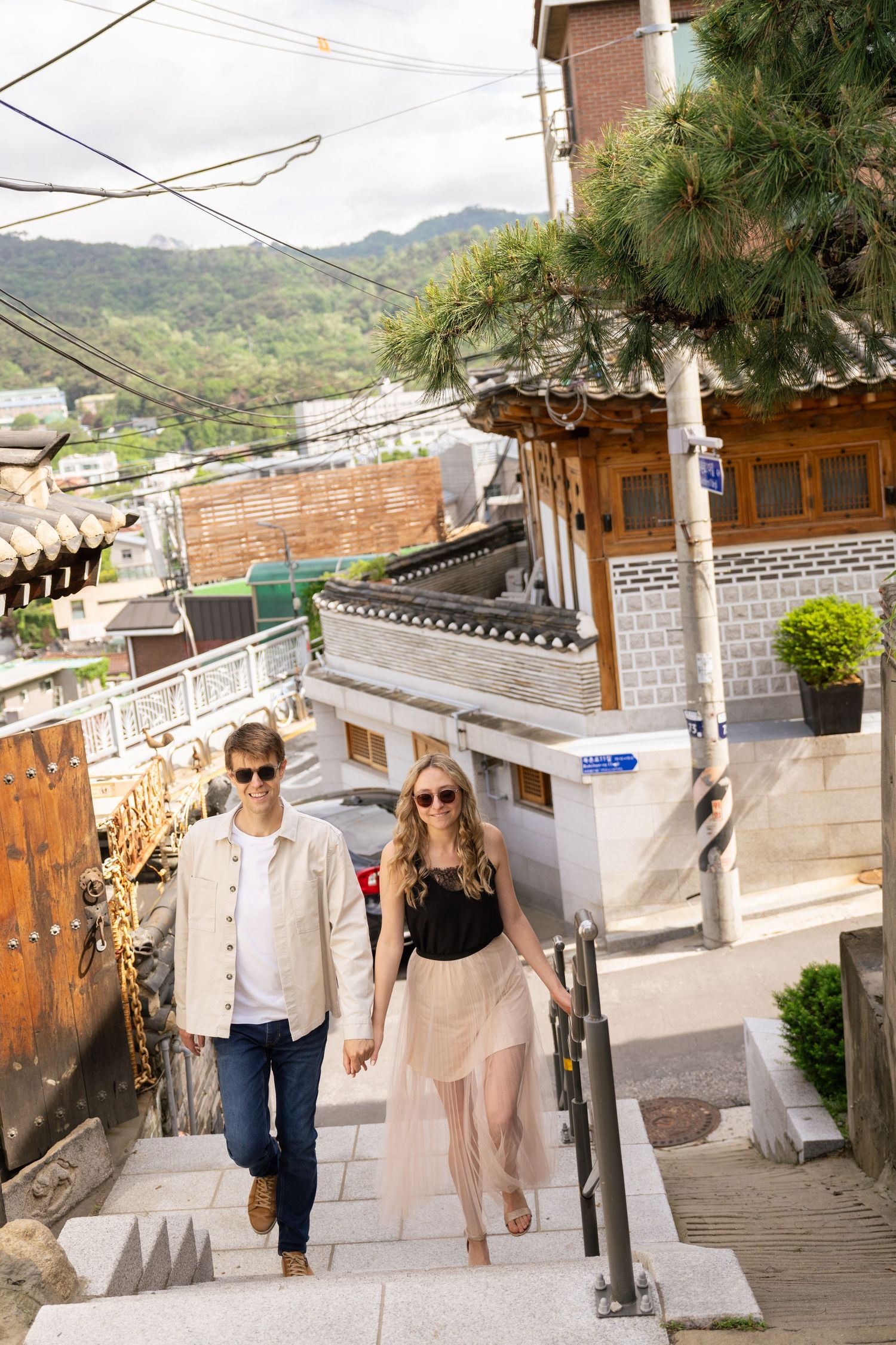 Tourists exploring traditional alleyways and architecture in Bukchon Hanok Village, Seoul, South Korea.