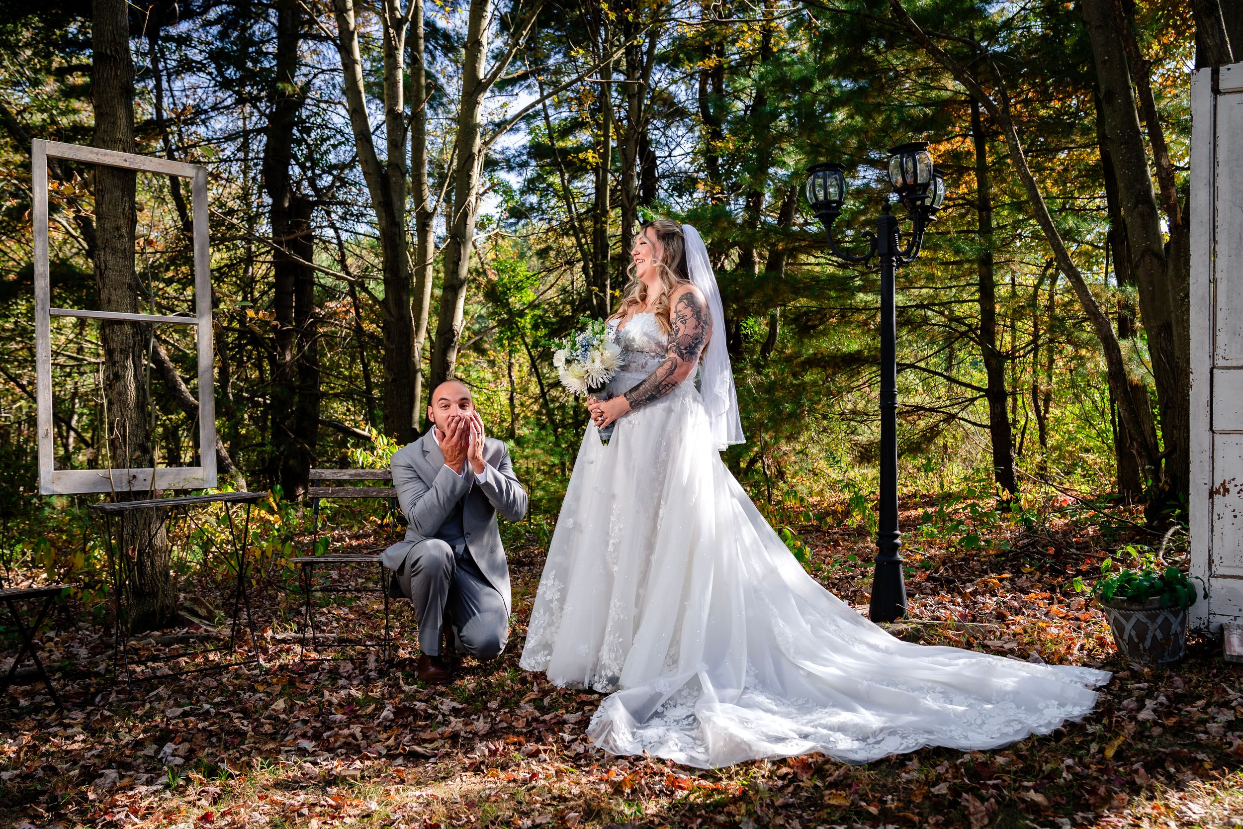 Wide angle view of wedding party portraits taken in front of rustic doors in autumn setting.