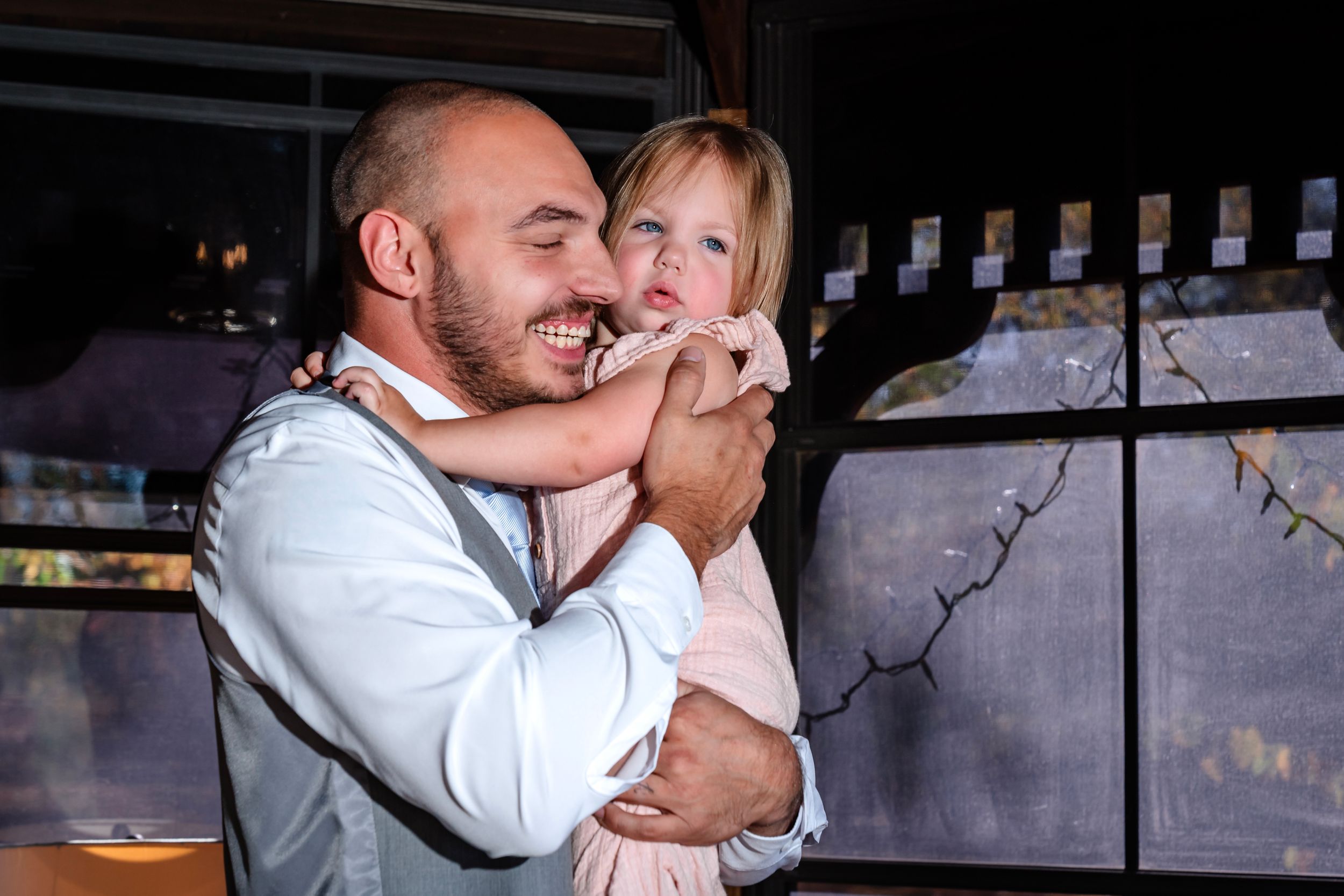 An emotional embrace captured in a rustic indoor setting.