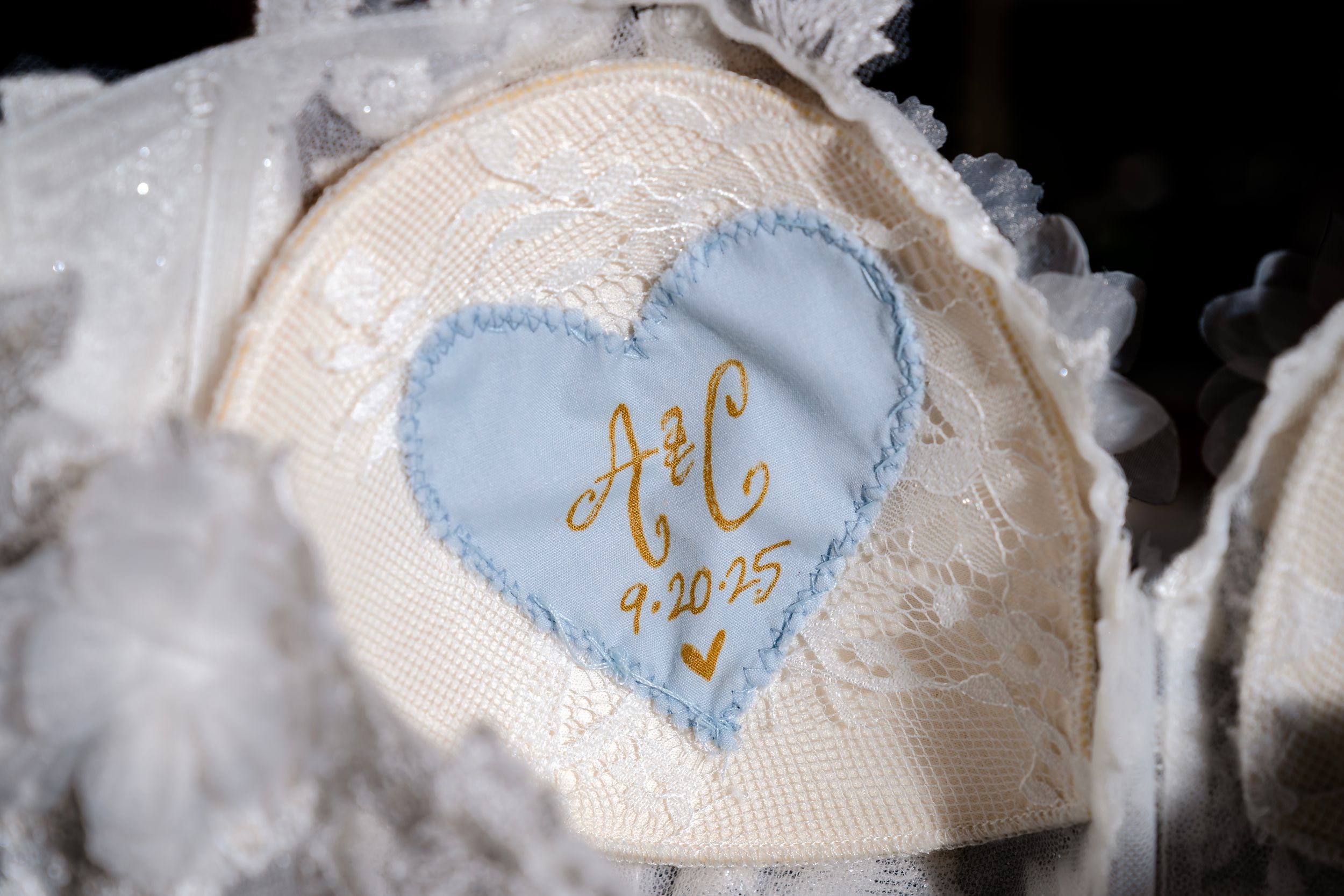 Close-up detail of delicate lace and blue fabric with gold embroidery.