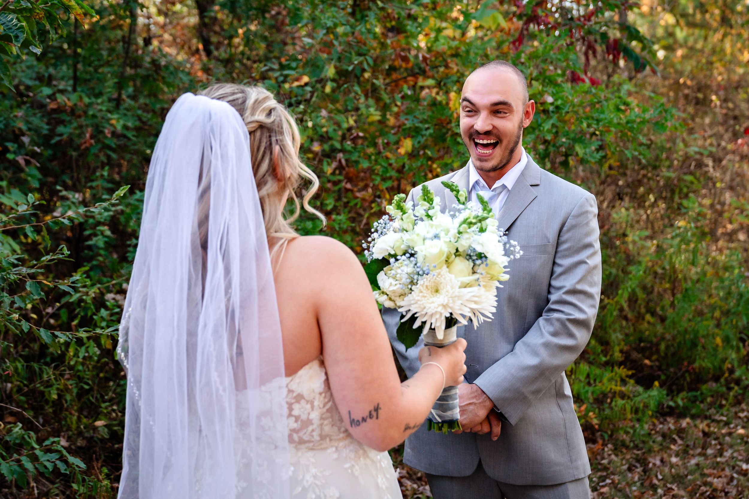 A romantic first look moment between newlyweds in an autumn garden setting with vibrant foliage.