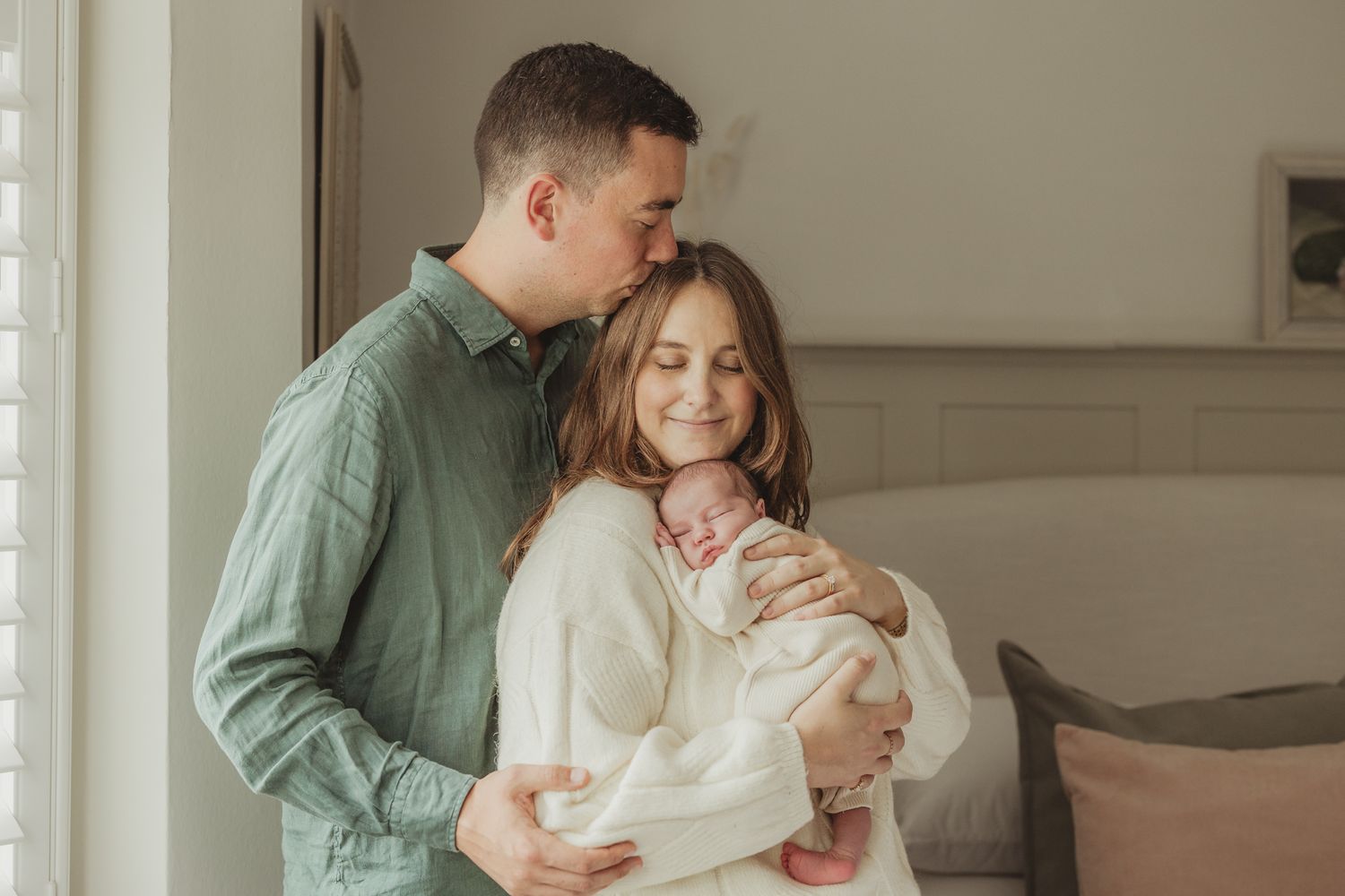 Natural light family portraits with newborn in casual setting.