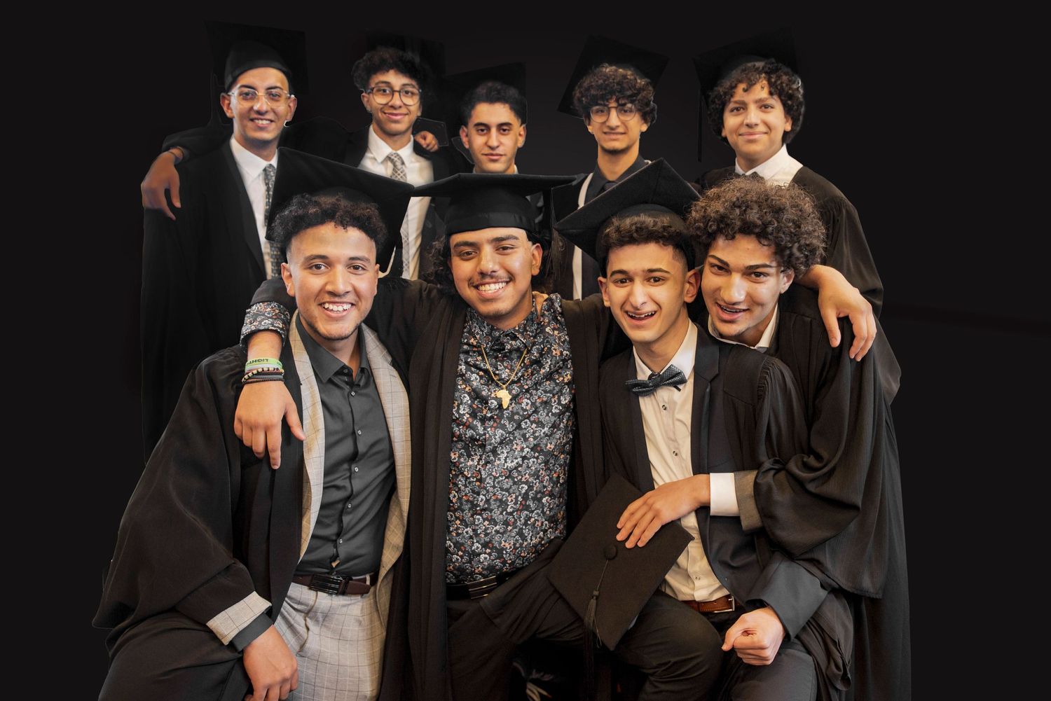 A group of performers pose together in black and white attire against a dark background.