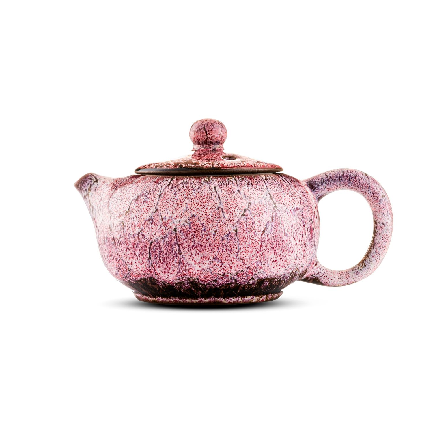 Pink ceramic teapot with textured glaze finish, rounded lid with knob handle, and loop handle on white background.