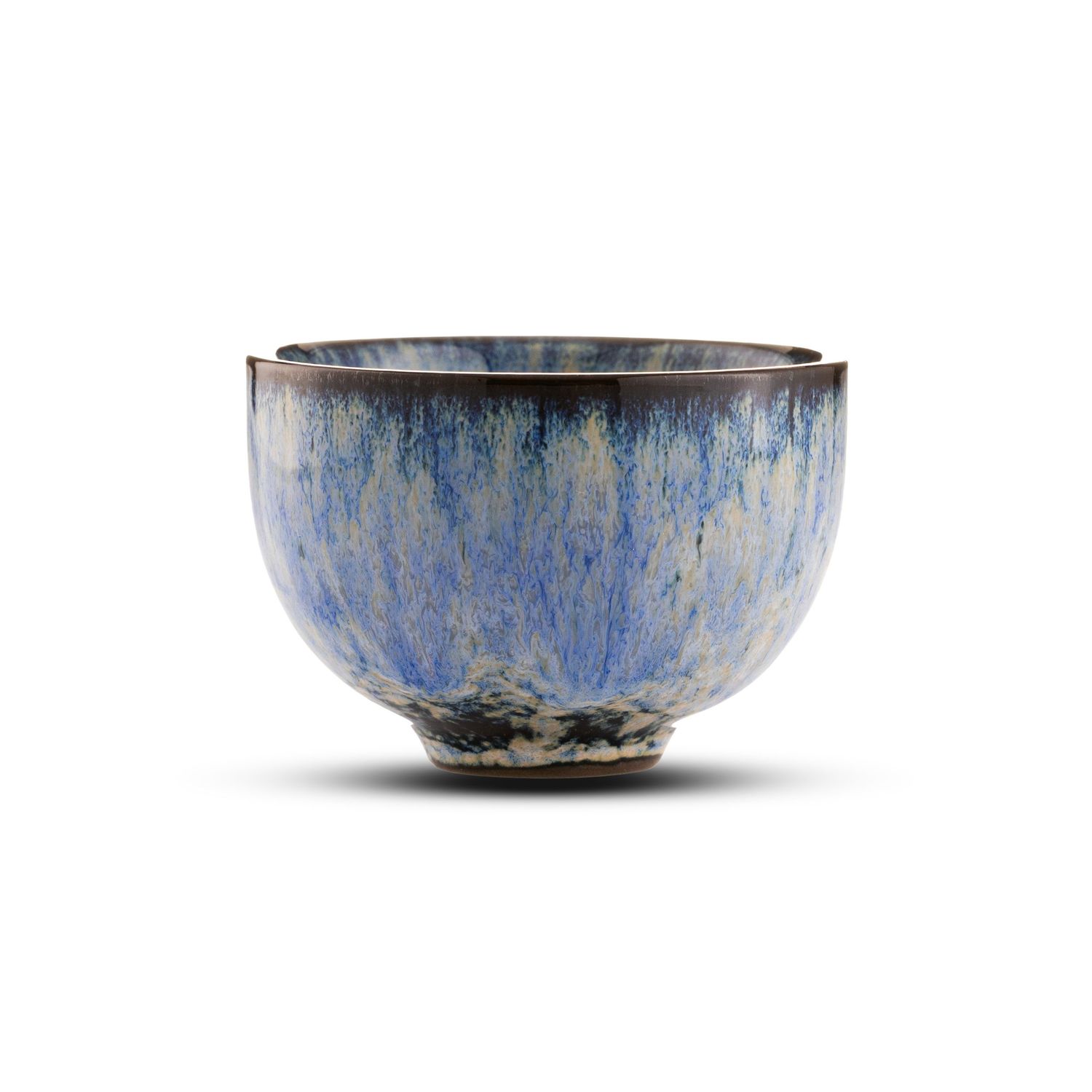 Handcrafted ceramic bowl with blue and gray reactive glaze, featuring a dark rim and textured finish on white background.
