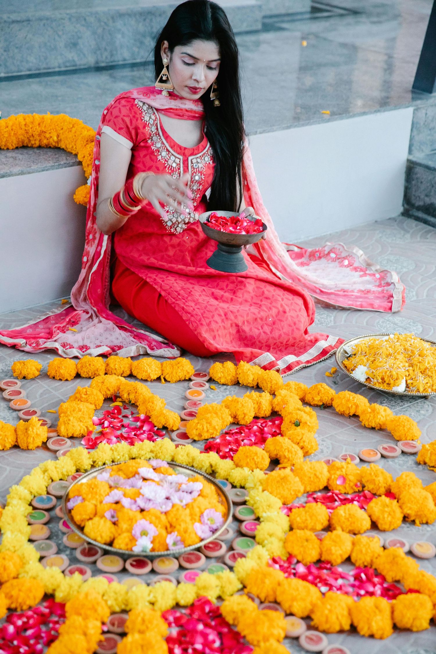Traditional Hindu puja thali with yellow and white flower garlands, bananas, and coconut for religious ceremony.
