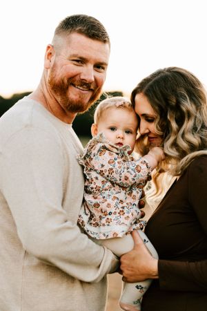 A couple pose with their young daughter at the Canebrake in Wagoner, Oklahoma during their fall family photo session.