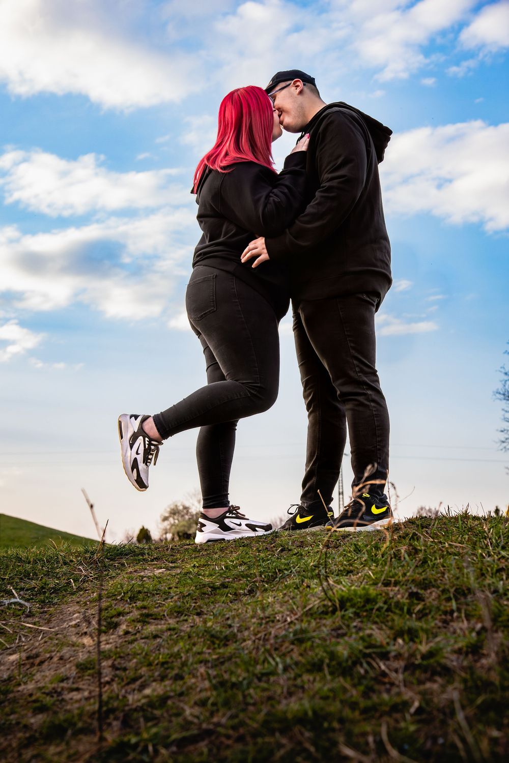 szerelmes pár csókolózik a fotózáson a kék ég alatt