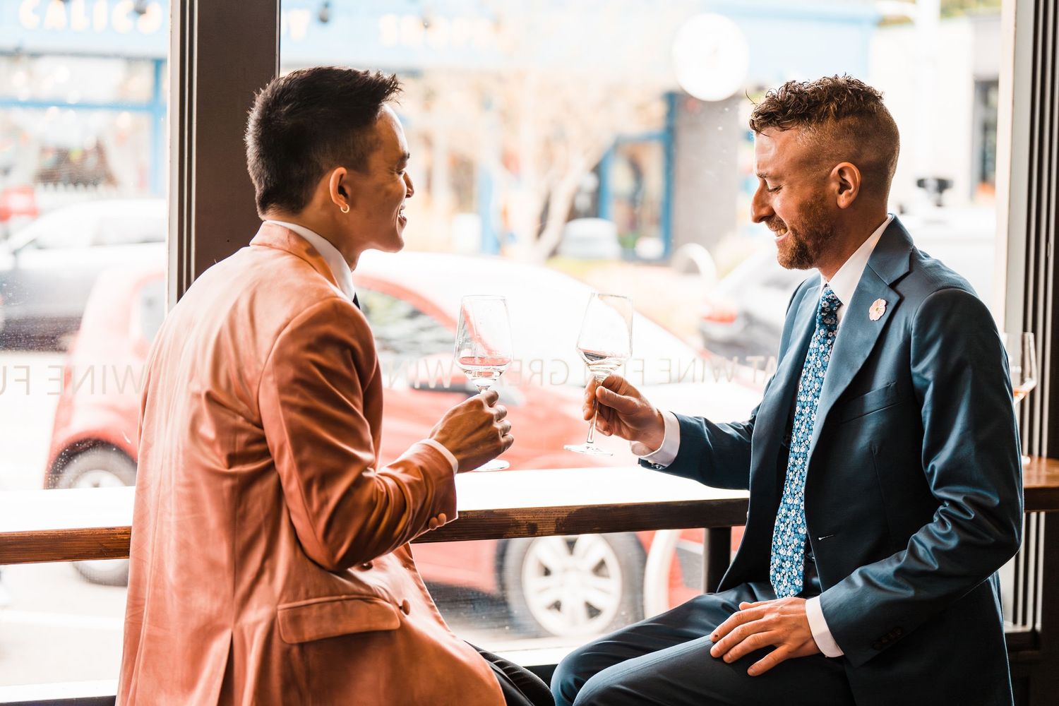Two businessmen in suits exchanging documents while having a conversation in a modern cafe setting. Bainbridge island ferry elopement