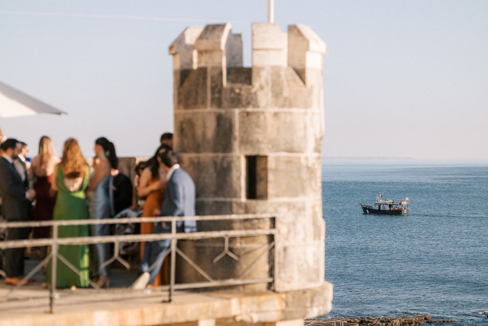 Wedding guests socialising during cocktail hour at Forte da Cruz seaside venue