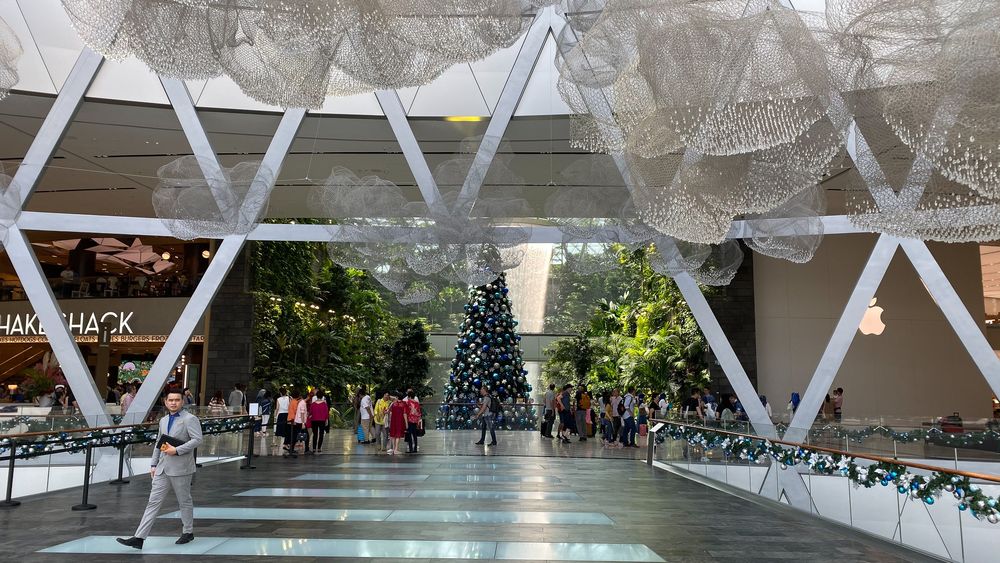 Changi Jewel, Singapore. Modern indoor shopping mall atrium with decorative hanging spheres and a Christmas tree display.