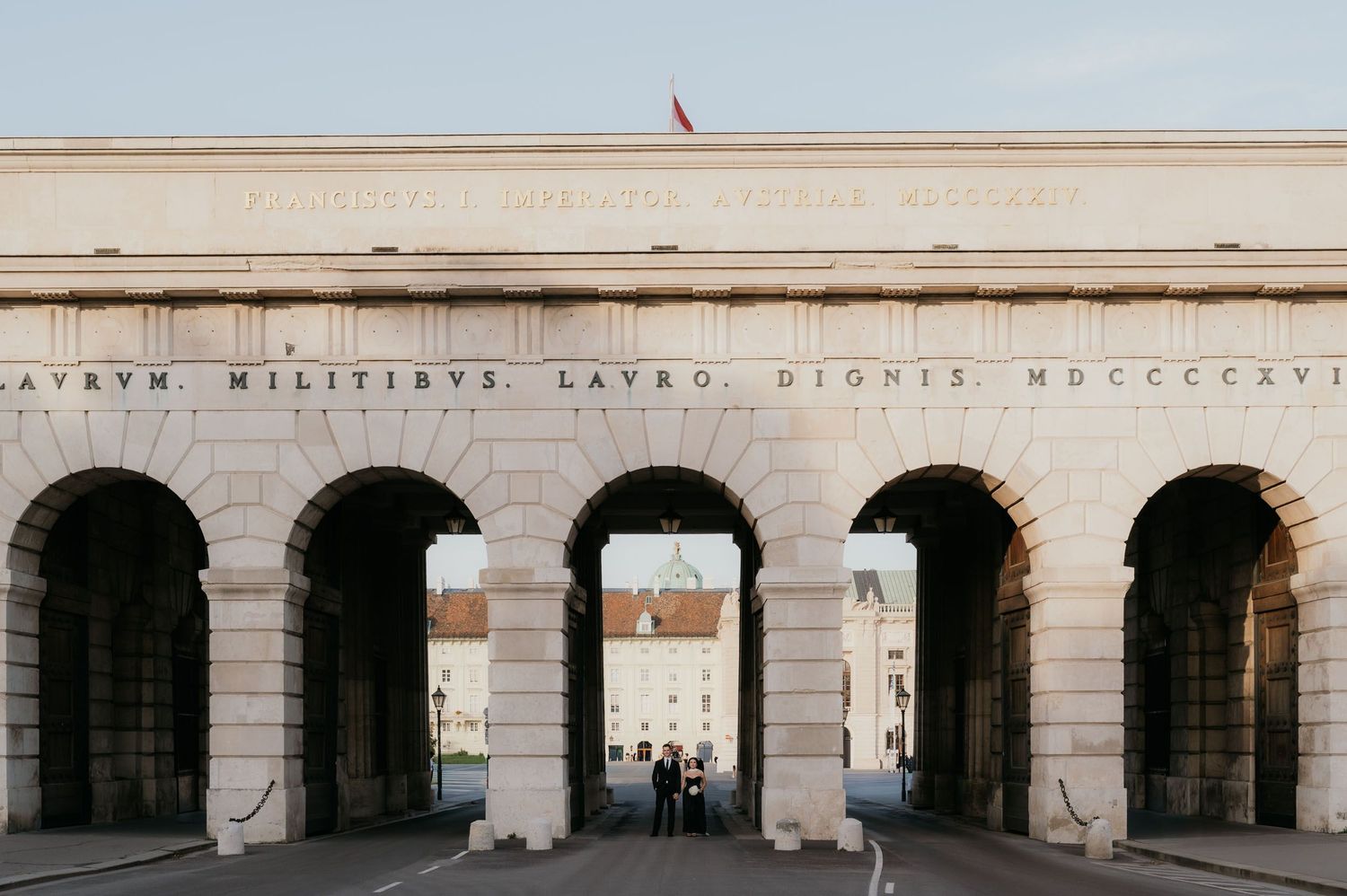 Historic stone archway monument with Latin inscription and arched passages in Vienna, Austria.