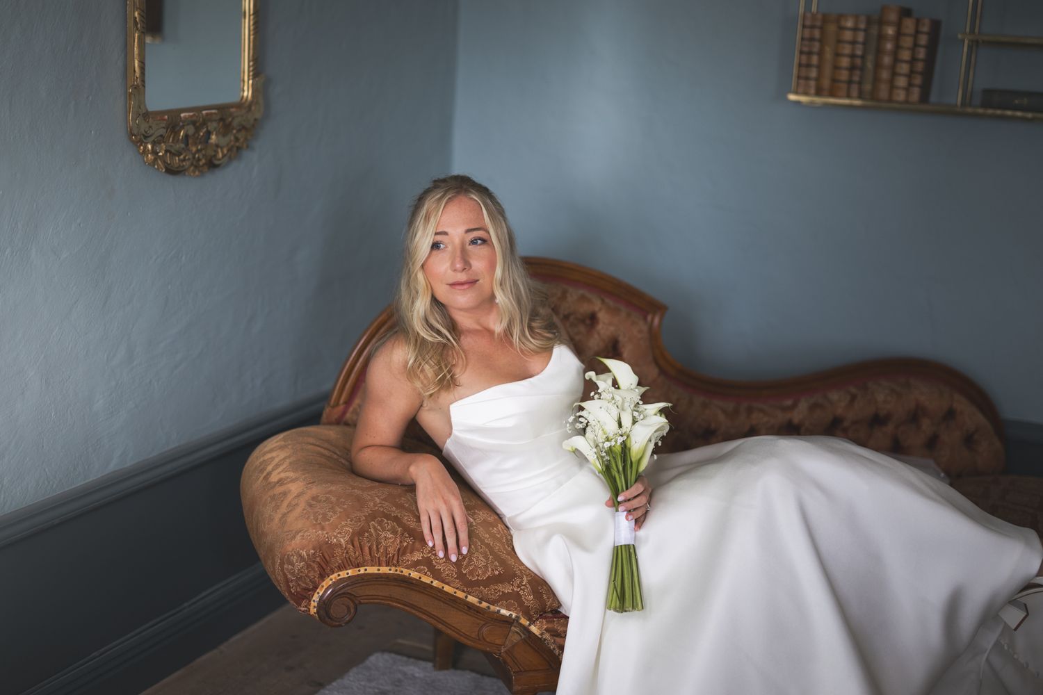 A bride in a white wedding gown poses in front of a brick archway for a series of romantic bridal portraits.