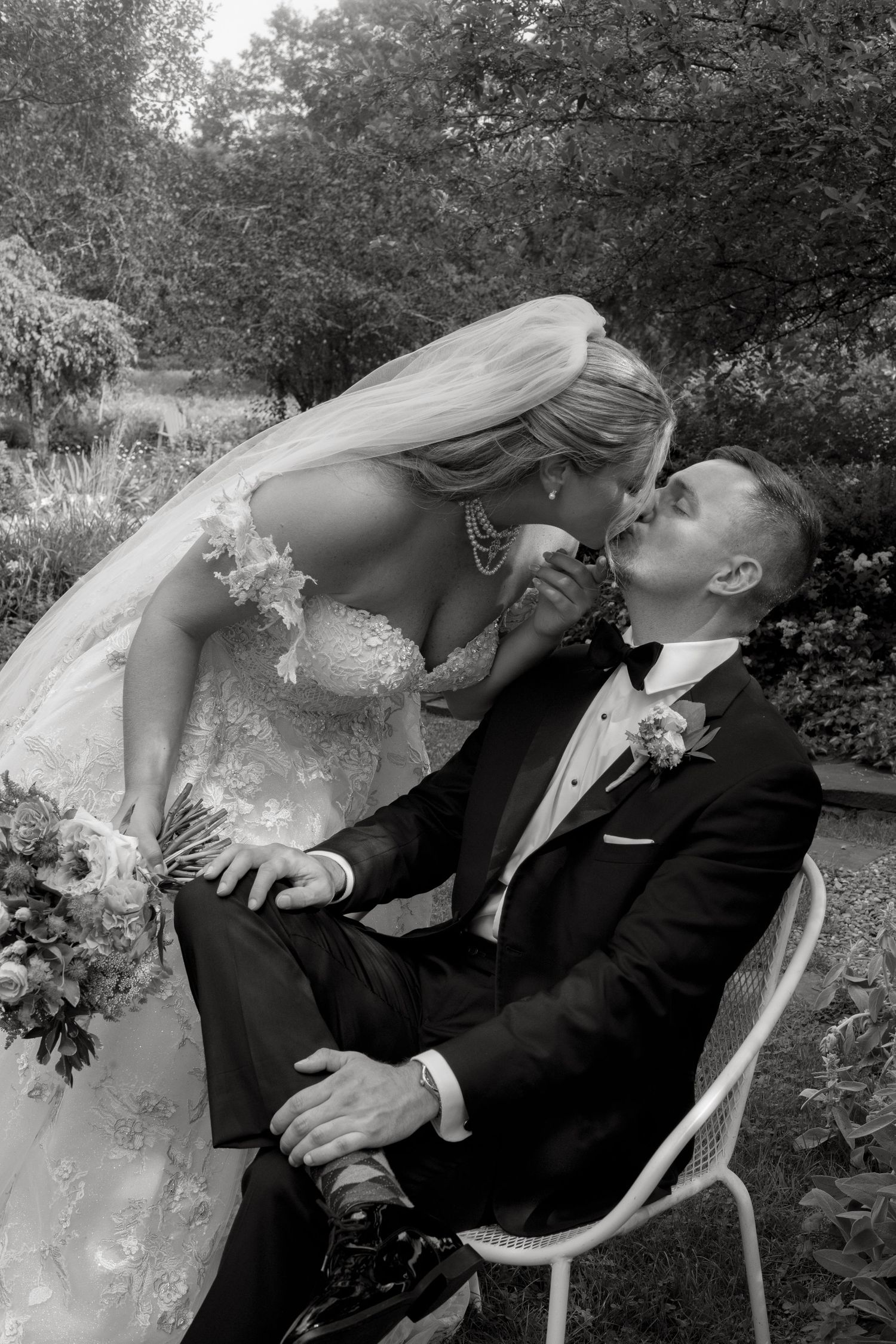 A joyful wedding moment captured outdoors with a stunning floral bouquet and elegant white gown with flowing train.