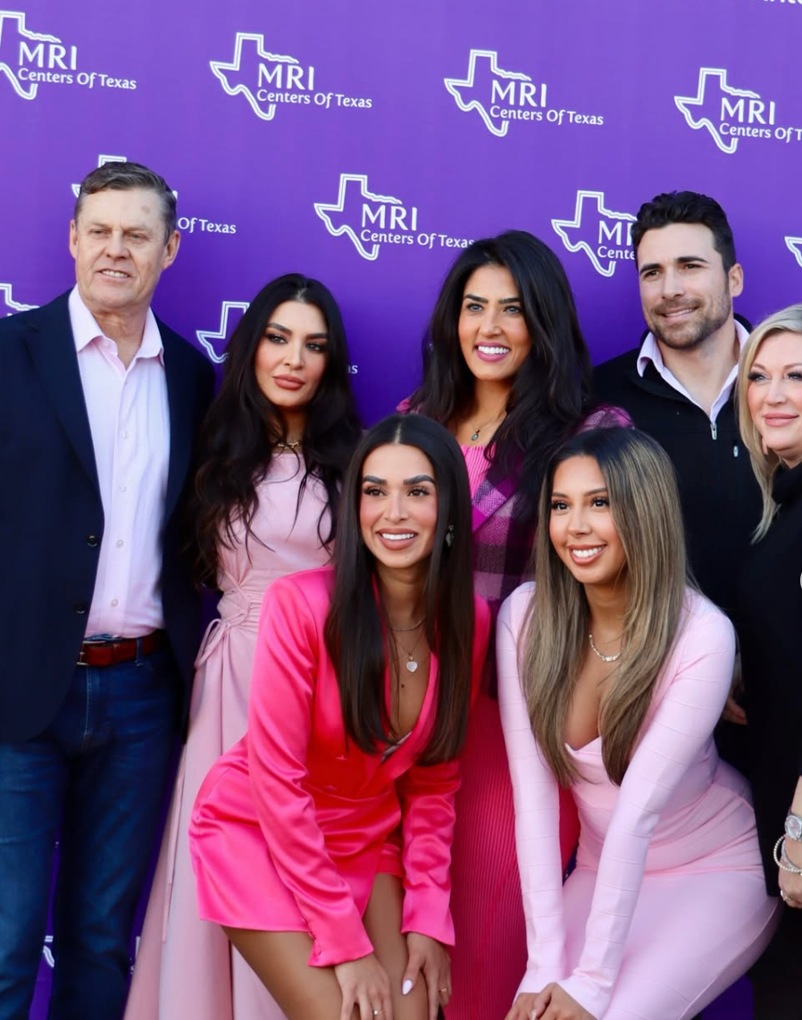 Group photo at a Galentine's Day 2026 event, featuring smiling women in pink outfits posing at an NRI photo booth.