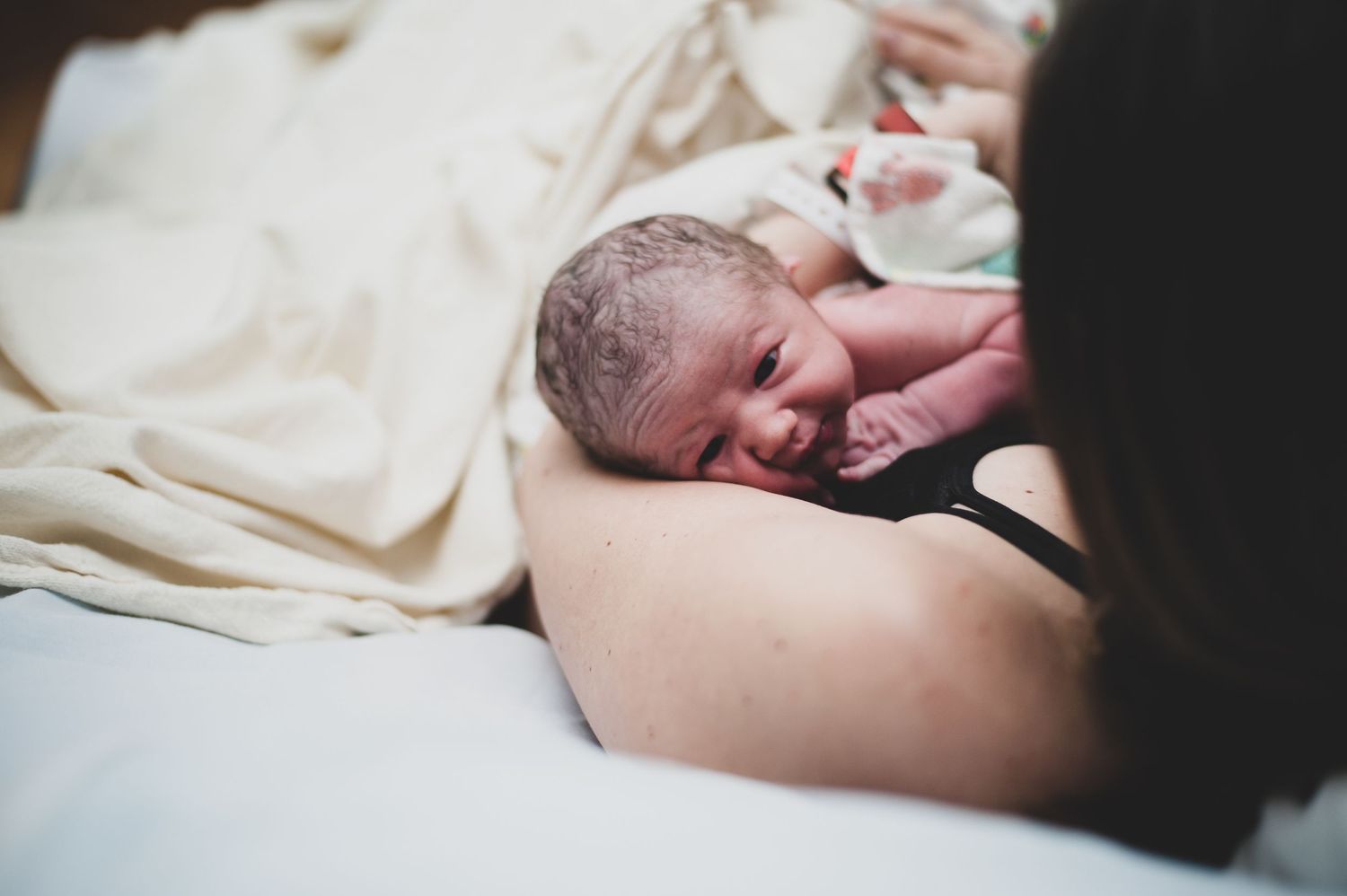 A close-up view of a newborn baby just moments after birth.