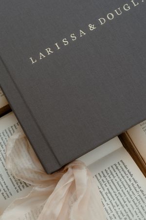 Gray book covers with elegant gold text overlaid on open book pages.