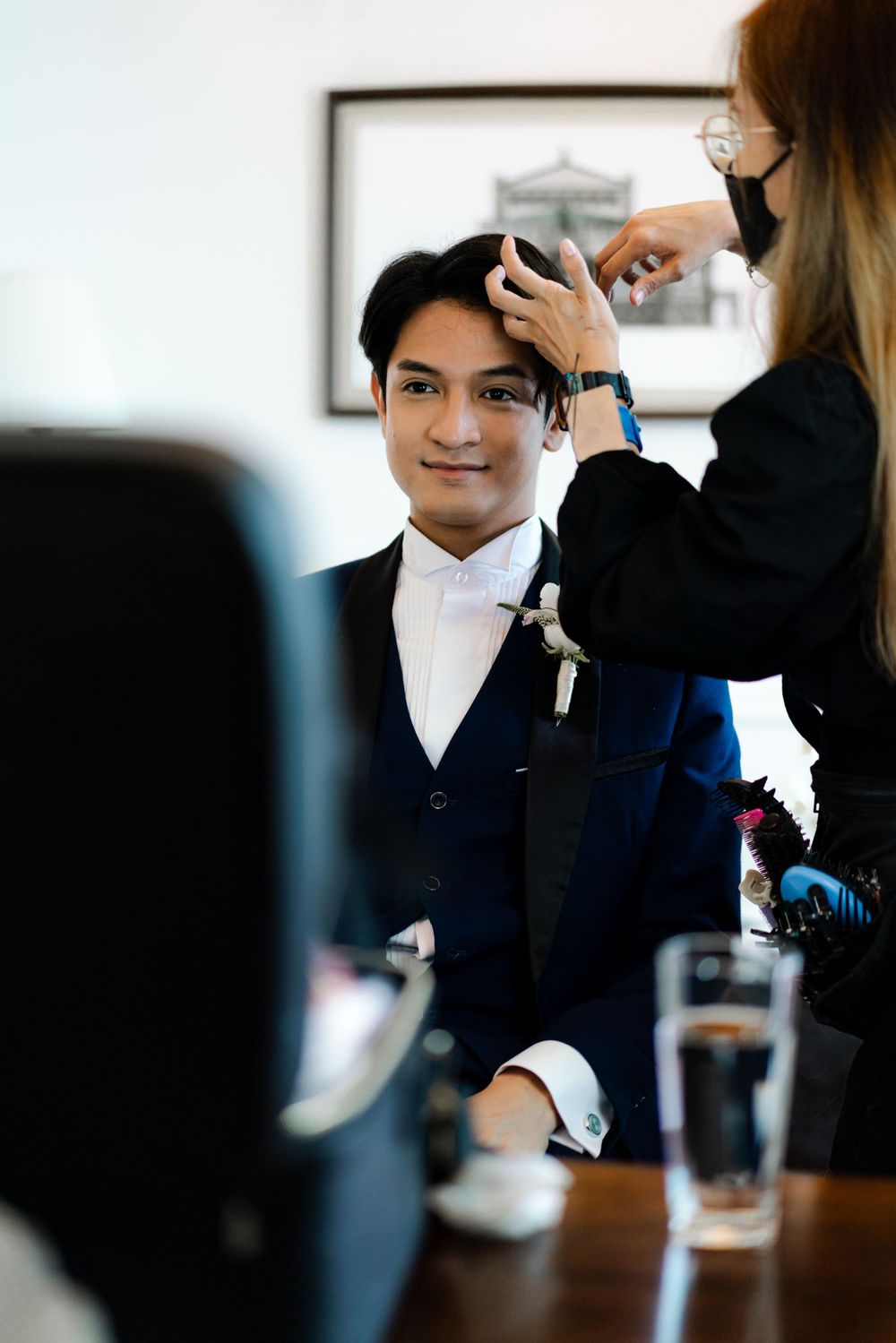 A stylist works on wedding preparation in a bright indoor setting.