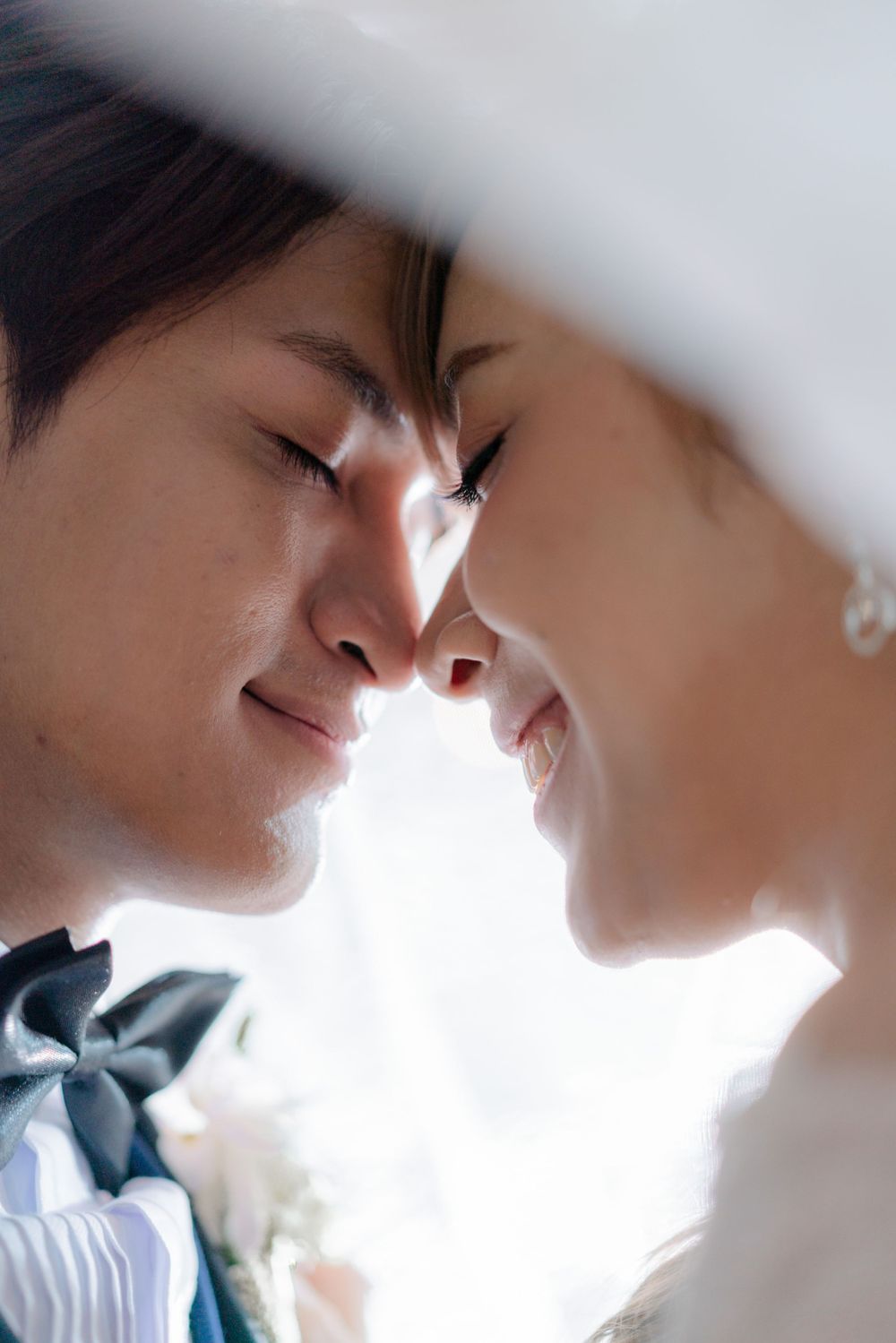 Intimate close-up wedding portrait with soft natural backlighting.