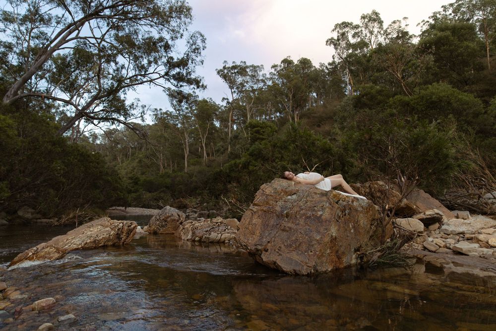 Panoramic view of rugged rock formations and eucalyptus trees along a scenic bushland trail in Australia.