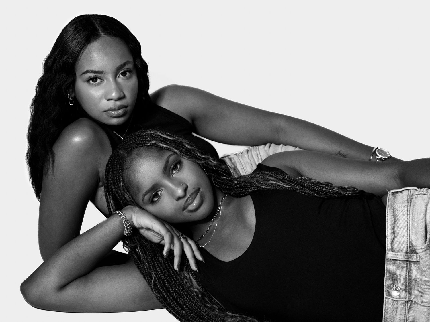 Artistic black and white portrait of two models in elegant pose.